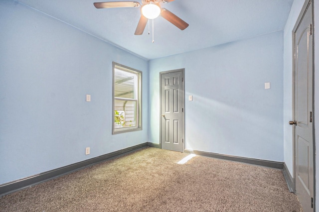 unfurnished bedroom with baseboards, a ceiling fan, and carpet