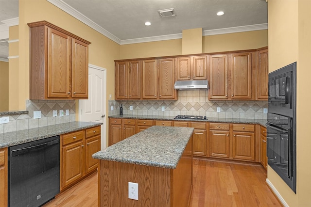 11406 Carson Ave, Pearland, TX 77584 - kitchen with visible vents, stone countertops, black appliances, light wood finished floors, and under cabinet range hood