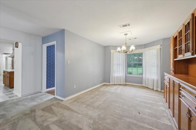 interior space with an inviting chandelier, baseboards, light colored carpet, and visible vents