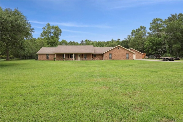 ranch-style home featuring covered porch, brick siding, and a front yard