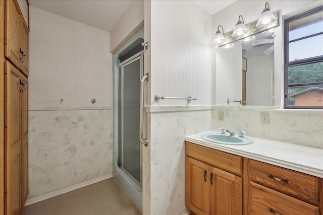 full bath with a shower with shower door and vanity