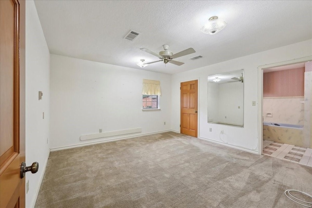 unfurnished bedroom featuring baseboards, ensuite bathroom, carpet, and visible vents