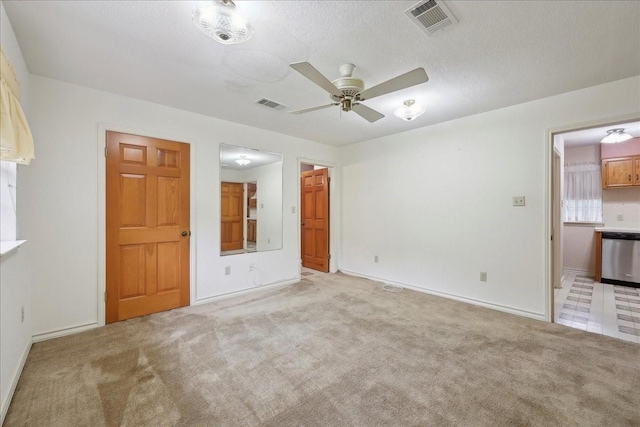 interior space with visible vents, ceiling fan, and light colored carpet
