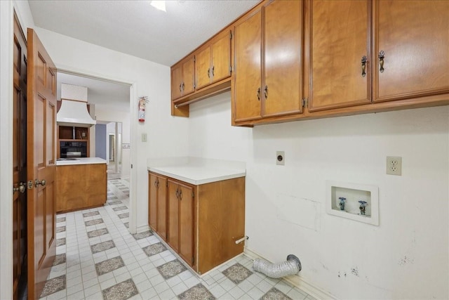 clothes washing area featuring hookup for an electric dryer, cabinet space, light tile patterned floors, baseboards, and hookup for a washing machine