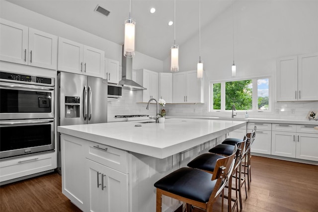 207 W Neyland St, Colmesneil, TX 75938 - kitchen with wall chimney range hood, white cabinets, light countertops, stainless steel appliances, and decorative backsplash
