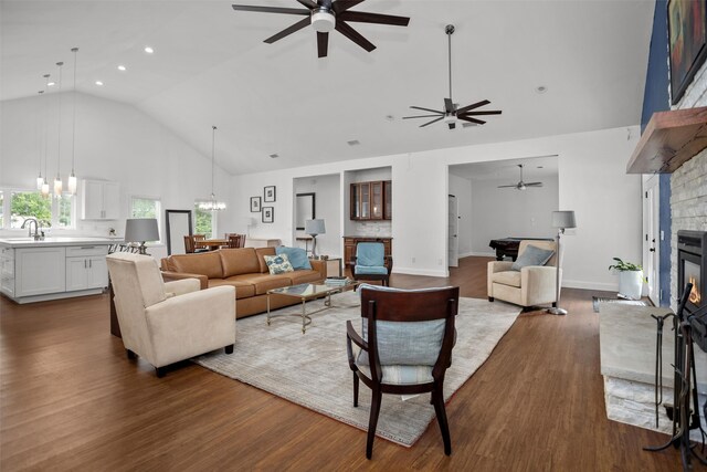 207 W Neyland St, Colmesneil, TX 75938 - living area with wood finished floors, a stone fireplace, high vaulted ceiling, recessed lighting, and ceiling fan with notable chandelier