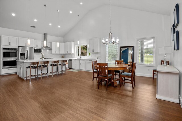 207 W Neyland St, Colmesneil, TX 75938 - dining room with plenty of natural light, dark wood finished floors, a chandelier, and high vaulted ceiling