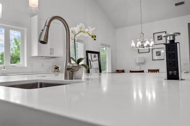 207 W Neyland St, Colmesneil, TX 75938 - room details with visible vents, a sink, light countertops, a notable chandelier, and white cabinetry