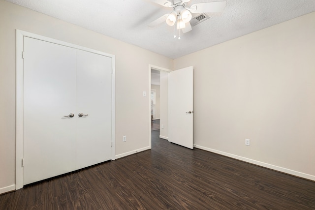 unfurnished bedroom with a ceiling fan, a closet, baseboards, dark wood finished floors, and visible vents