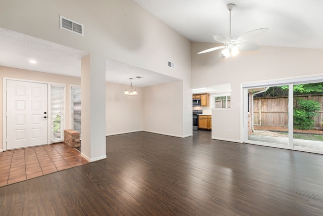 unfurnished living room with dark wood-style flooring, ceiling fan with notable chandelier, high vaulted ceiling, and visible vents