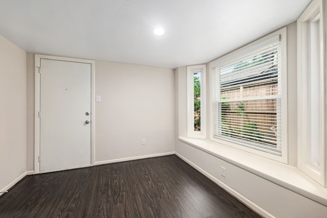spare room featuring dark wood-style flooring, baseboards, and recessed lighting