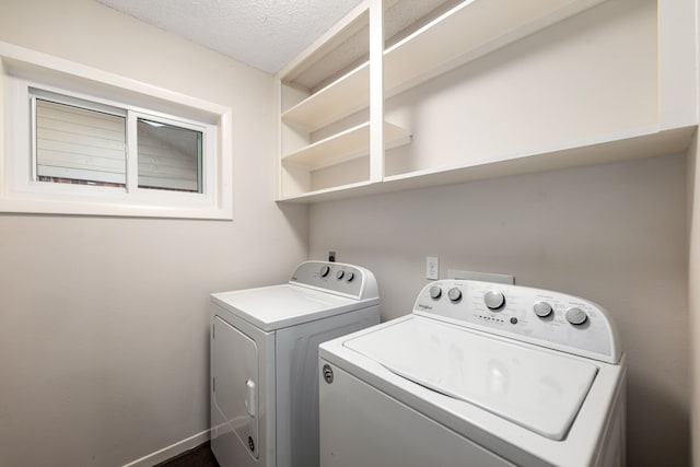 washroom featuring laundry area, a textured ceiling, and washer and dryer