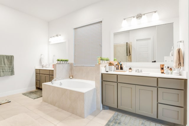 full bathroom featuring two vanities, a bath, tile patterned flooring, and baseboards