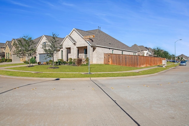 view of front facade with brick siding, a garage, and a residential view