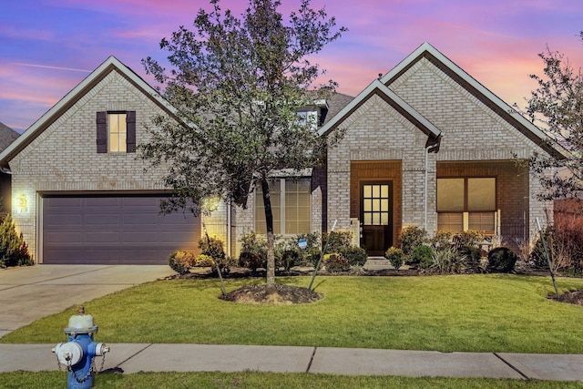 view of front of home with a front yard, an attached garage, brick siding, and driveway