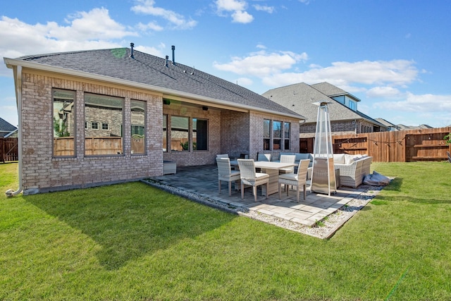 rear view of property featuring a patio area, outdoor lounge area, brick siding, and roof with shingles