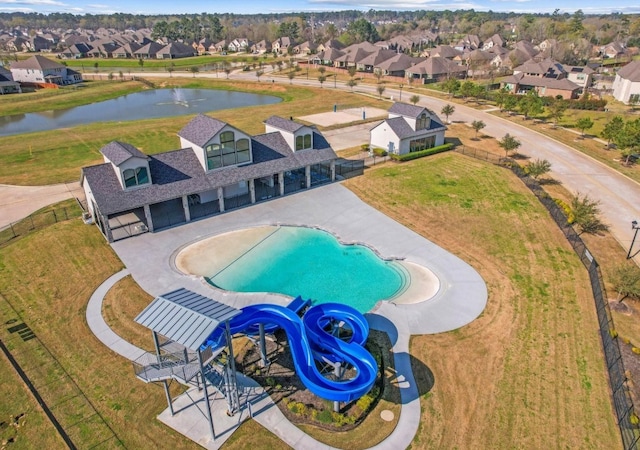 aerial perspective of suburban area featuring a large body of water and a pool