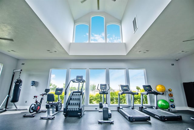 gym with high vaulted ceiling and baseboards