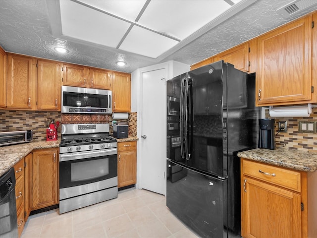 11602 Stone Bridge Dr, Houston, TX 77064 - kitchen with appliances with stainless steel finishes, decorative backsplash, light stone countertops, light tile patterned flooring, and brown cabinetry