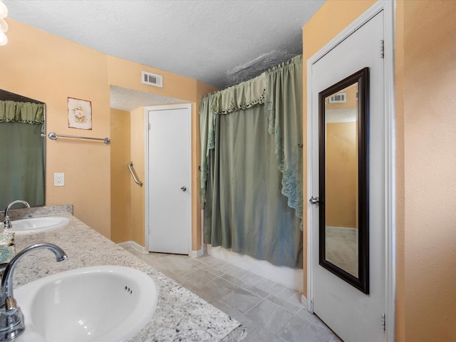 11602 Stone Bridge Dr, Houston, TX 77064 - full bathroom with a textured ceiling, tile patterned floors, double vanity, and baseboards