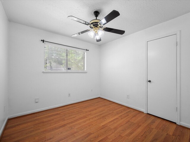 11602 Stone Bridge Dr, Houston, TX 77064 - unfurnished room featuring light wood-style floors, a textured ceiling, a ceiling fan, and baseboards