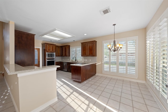 kitchen with visible vents, a peninsula, appliances with stainless steel finishes, and light countertops