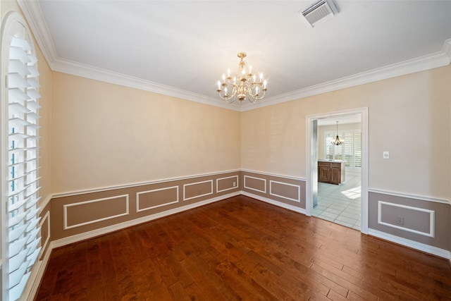 empty room with an inviting chandelier, crown molding, and visible vents
