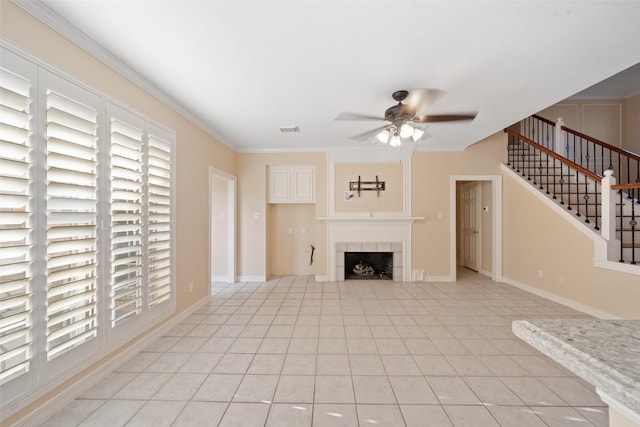 unfurnished living room with stairs, ceiling fan, visible vents, and a wealth of natural light