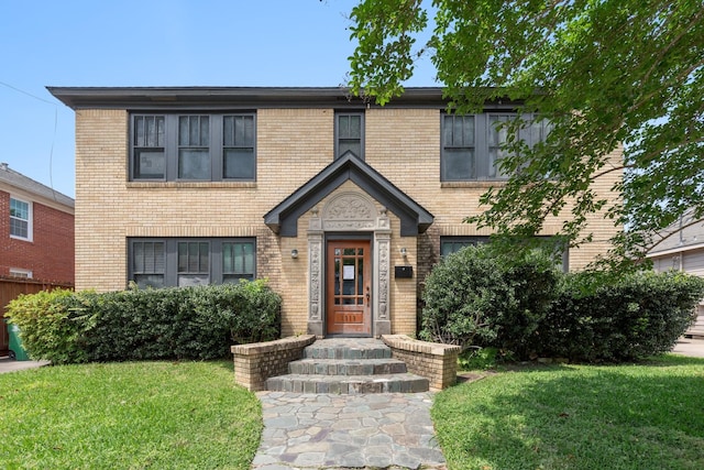 view of front of house featuring brick siding and a front yard