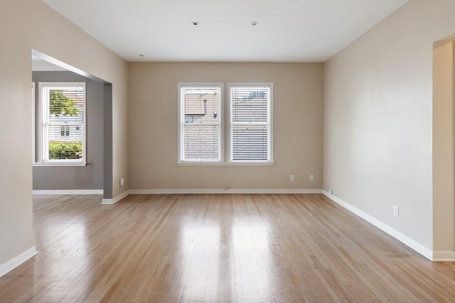 empty room with light wood-style floors and baseboards