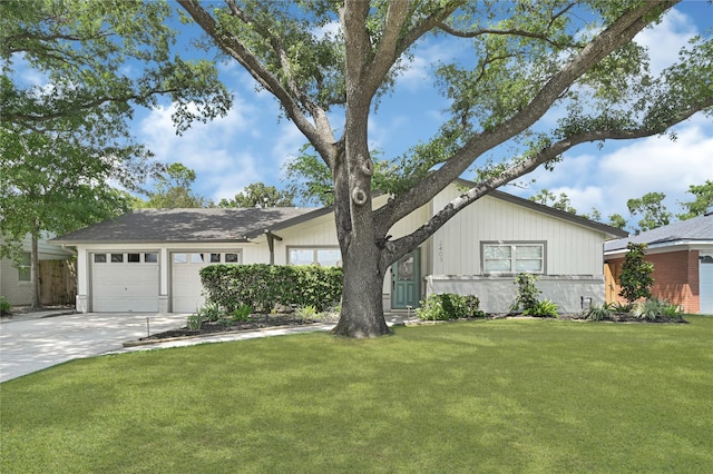 single story home with concrete driveway, an attached garage, and a front yard