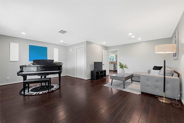 living room featuring visible vents, ornamental molding, baseboards, and hardwood / wood-style flooring