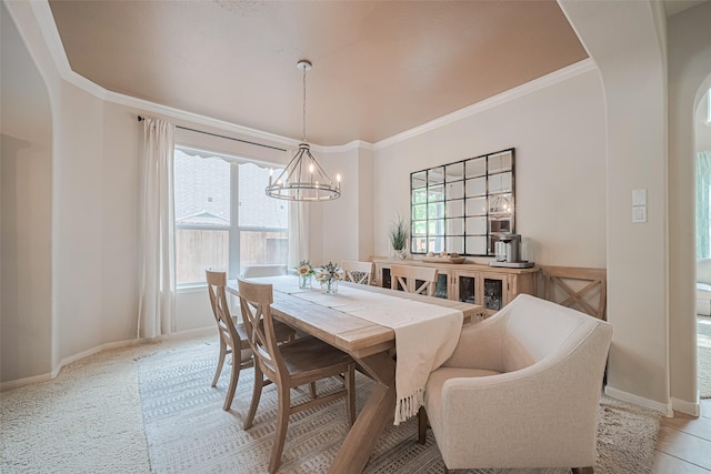 dining room featuring ornamental molding, arched walkways, and a notable chandelier