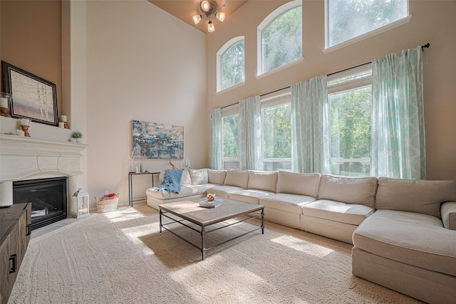 living area featuring a glass covered fireplace and a high ceiling