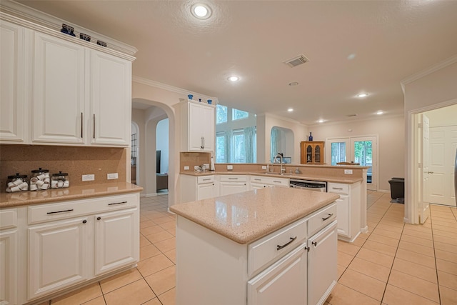 kitchen featuring visible vents, arched walkways, a peninsula, and light tile patterned floors