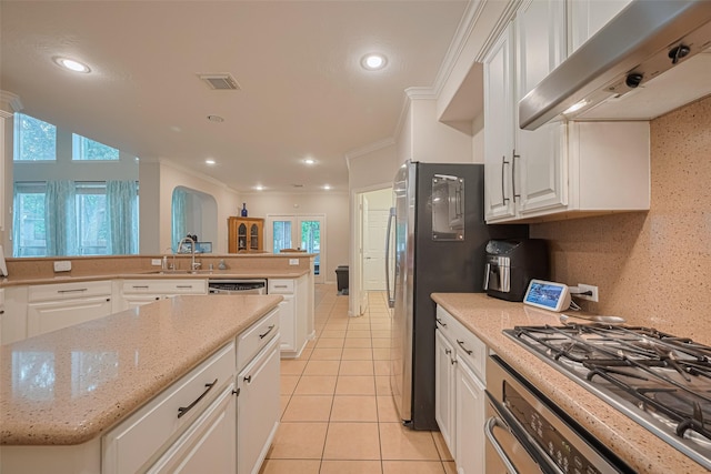 kitchen featuring a sink, white cabinetry, light tile patterned floors, under cabinet range hood, and visible vents