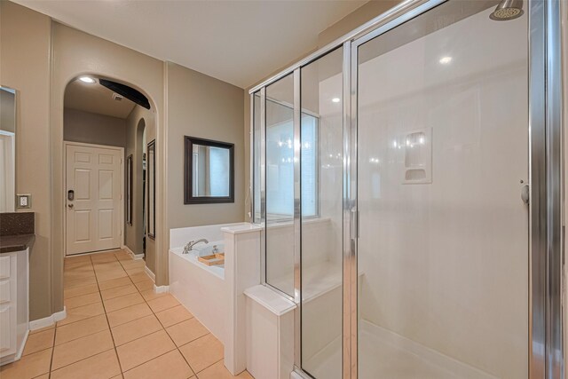 full bath featuring tile patterned flooring, vanity, baseboards, a shower stall, and a bath