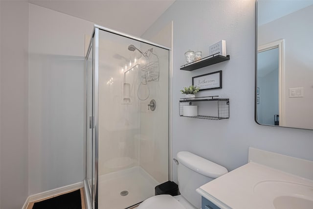 bathroom with vanity, toilet, and a shower stall