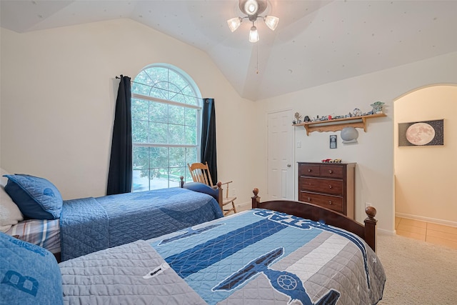 carpeted bedroom featuring baseboards, tile patterned floors, and lofted ceiling