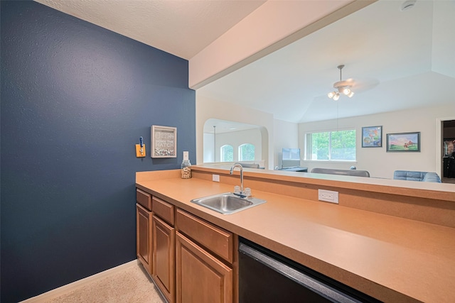 kitchen featuring light carpet, a sink, baseboards, open floor plan, and dishwashing machine