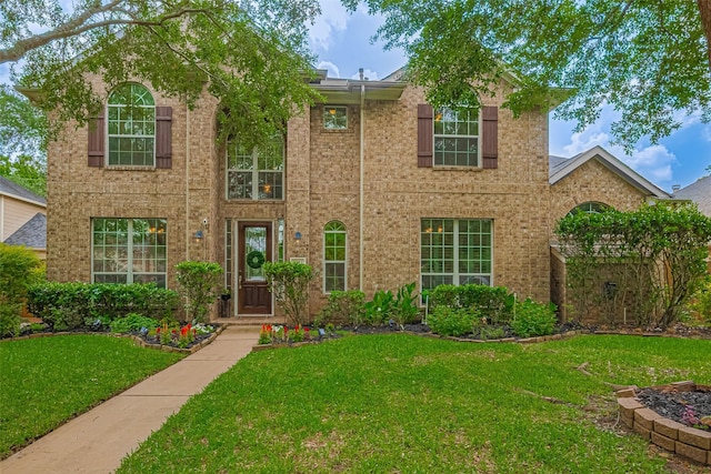 view of front of house featuring brick siding and a front yard