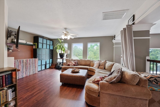 living area with ceiling fan, wood finished floors, and visible vents