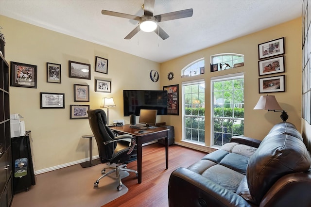 office featuring baseboards, a ceiling fan, and wood finished floors
