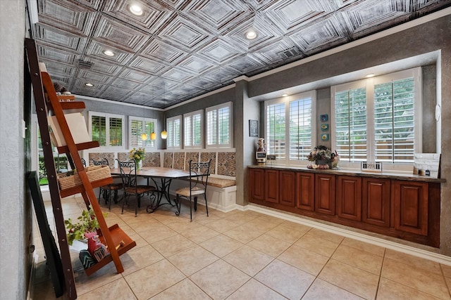 dining room with crown molding, an ornate ceiling, and light tile patterned flooring