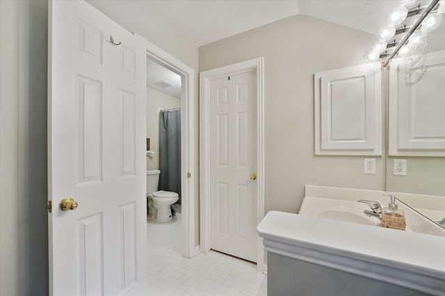 bathroom featuring toilet, lofted ceiling, tile patterned flooring, and vanity