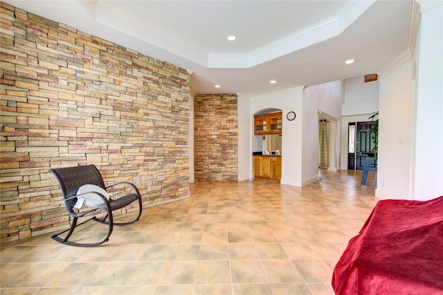 living area featuring recessed lighting, arched walkways, ornamental molding, and a raised ceiling