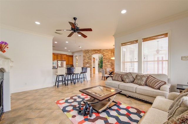 living room with visible vents, baseboards, recessed lighting, arched walkways, and a ceiling fan