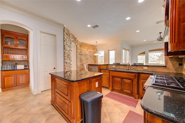 kitchen featuring brown cabinets, light tile patterned flooring, appliances with stainless steel finishes, a sink, and visible vents