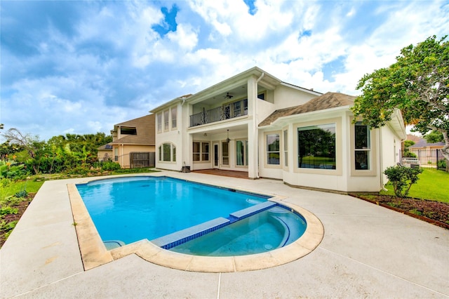 view of swimming pool featuring a ceiling fan, a patio area, fence, and a pool with connected hot tub