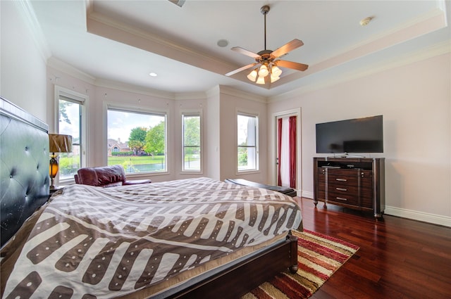 bedroom with a raised ceiling, a ceiling fan, baseboards, ornamental molding, and hardwood / wood-style flooring